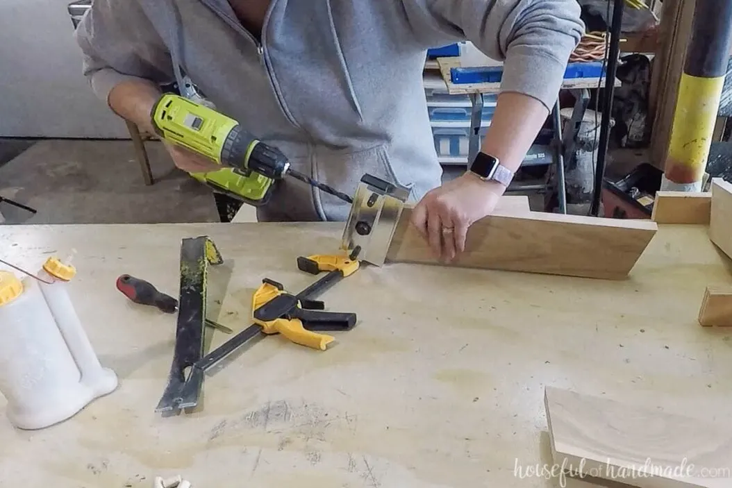 Drilling dowel pin holes in the top of the leg pieces with a self-centering doweling jig. 