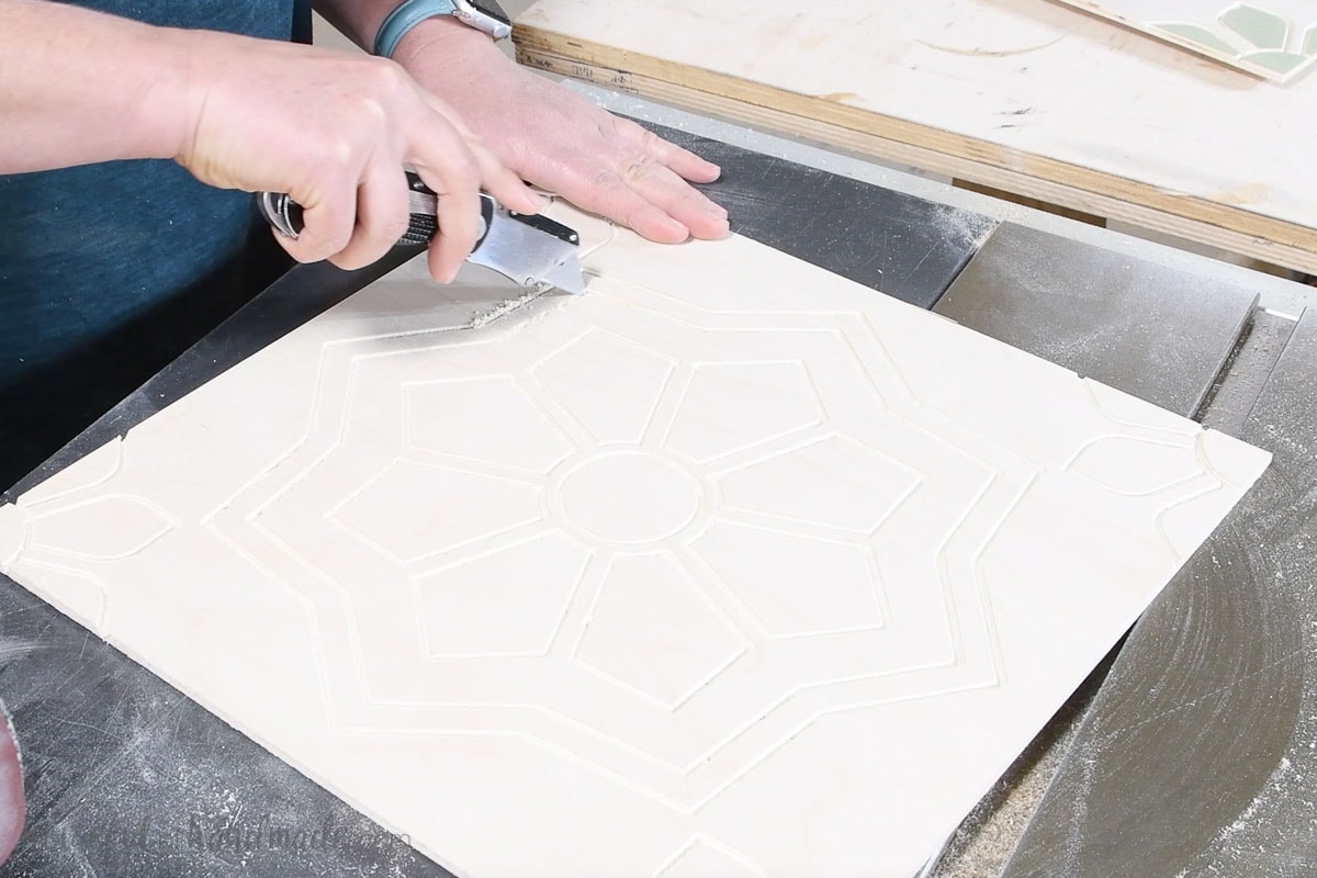 Cleaning up the carve on the plywood with a utility knife. 