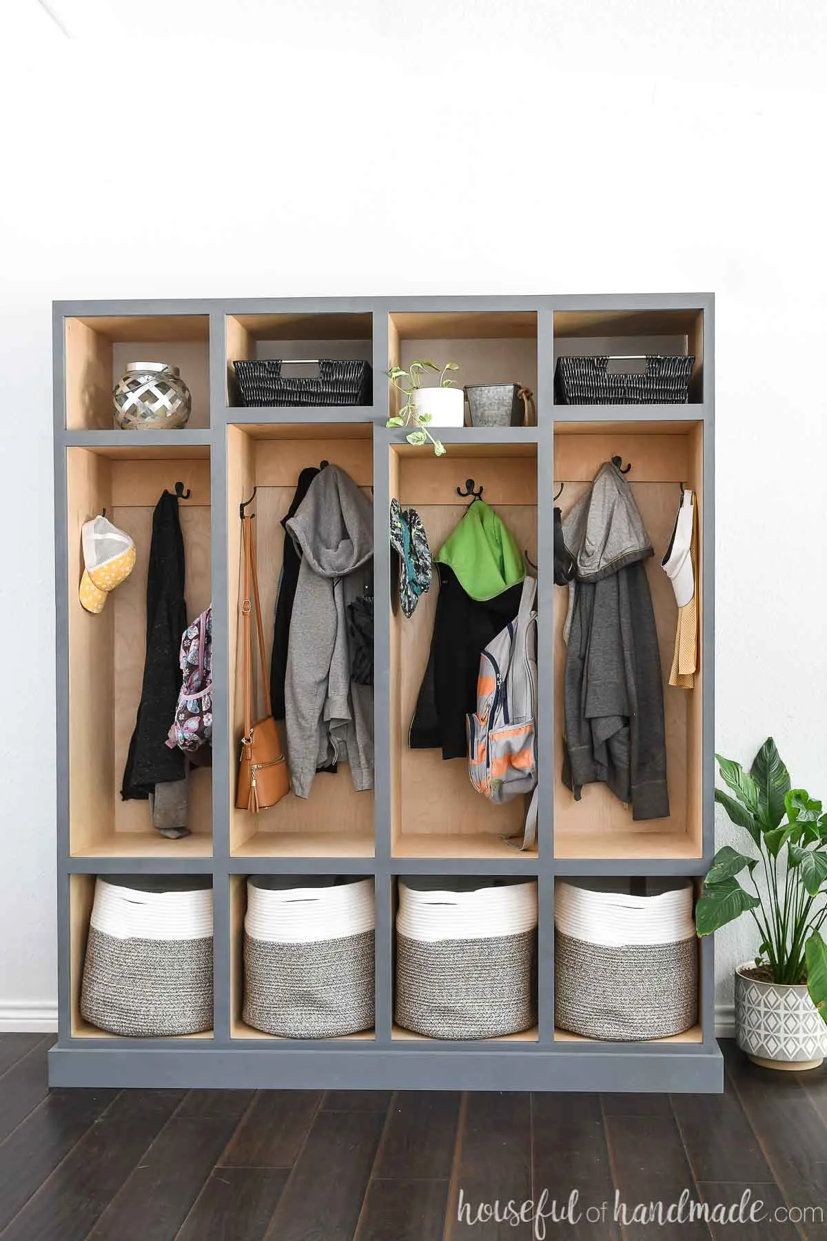 Straight on view of the mudroom lockers with a plant next to it.