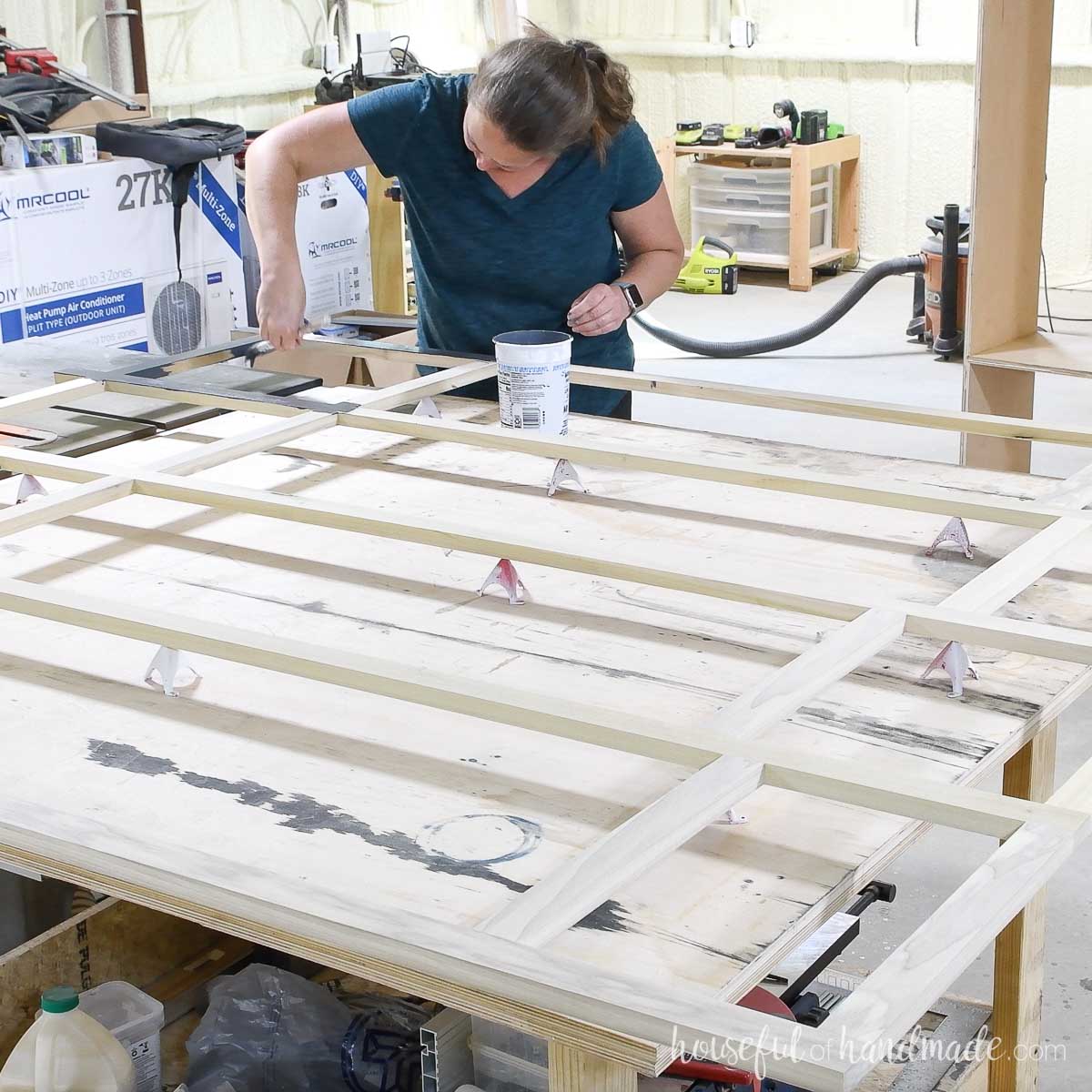 Painting the assembled face frame with a navy blue chalk paint. 