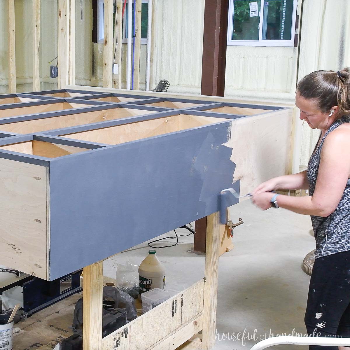 Painting the exterior of the mudroom lockers with a foam roller. 