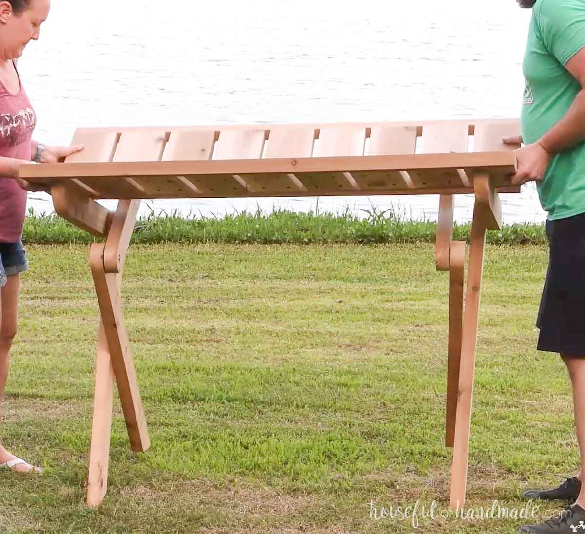Two people folding down the picnic table.