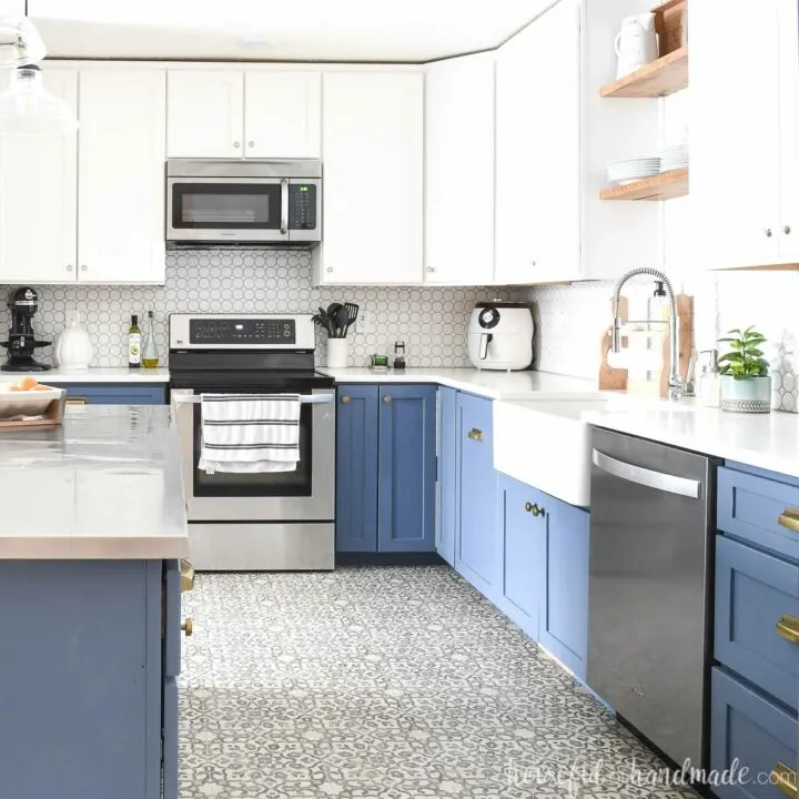 Blue and white kitchen cabinets in an open kitchen with full overlay cabinet doors.