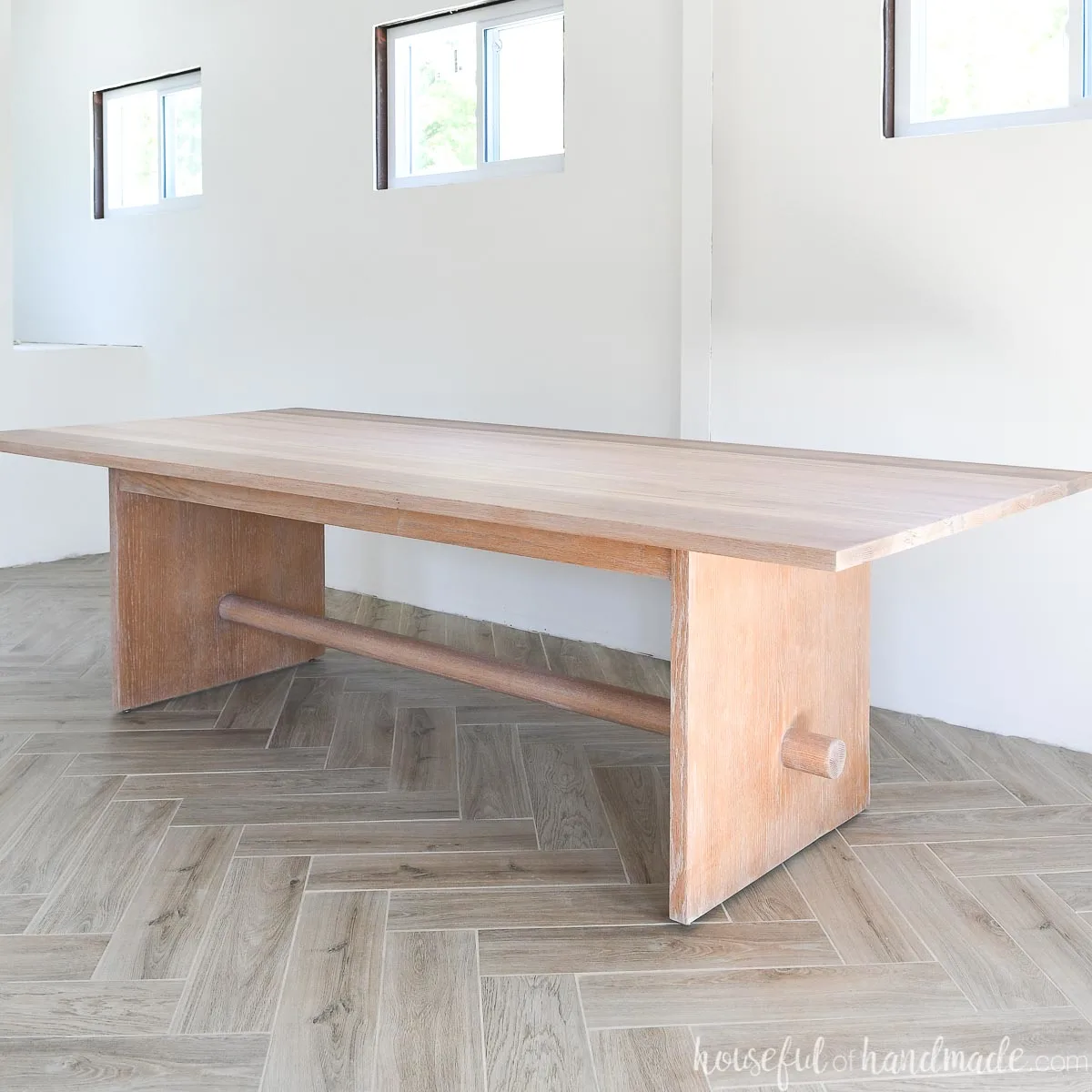 Gorgeous oak conference table refinished with TrueTone Pickled White stain sitting on herringbone patterned wood tile floor. 