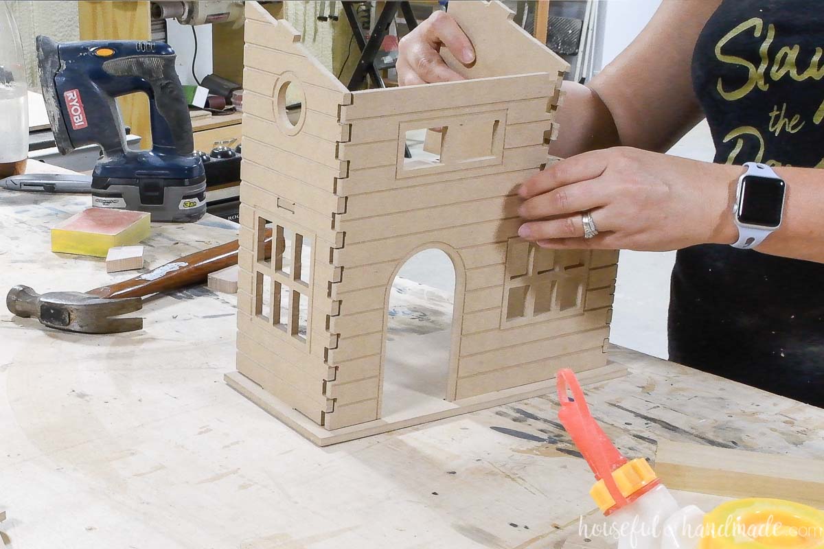 Attaching the top floor side to the doll house. 
