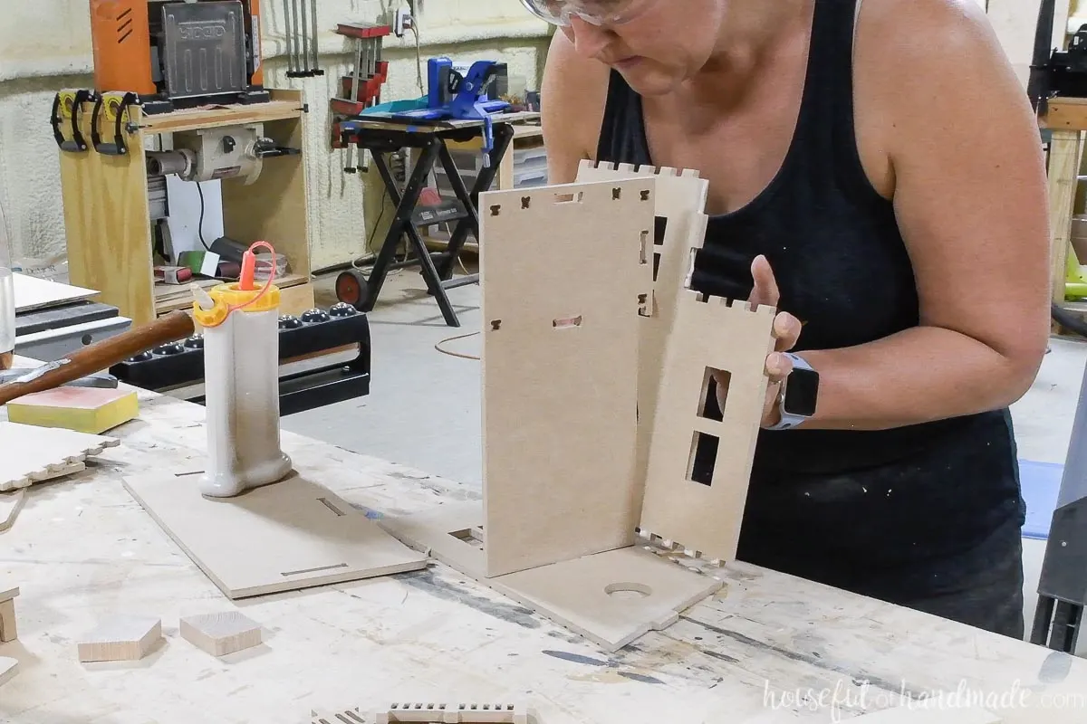 Pressing the pieces of the DIY dollhouse together with wood glue and tabs. 