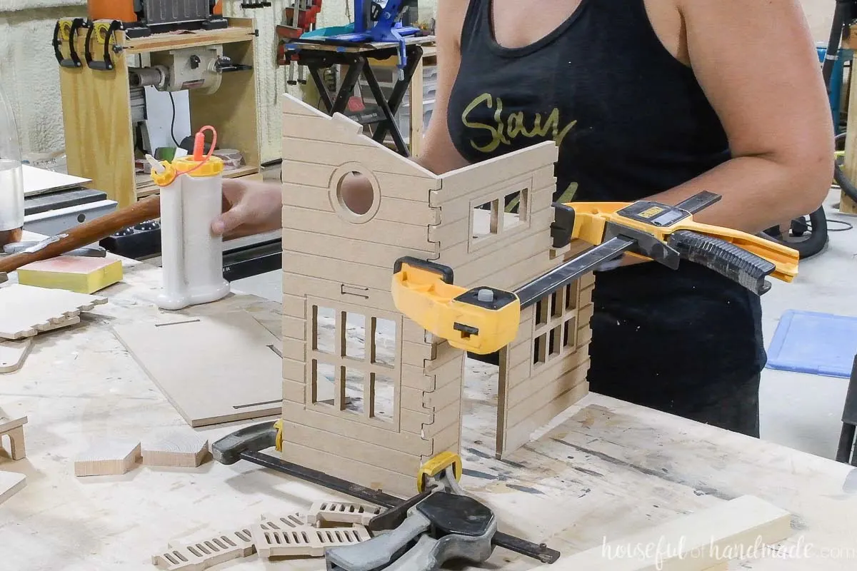 Using clamps to hold the wooden dollhouse together while the glue dries. 