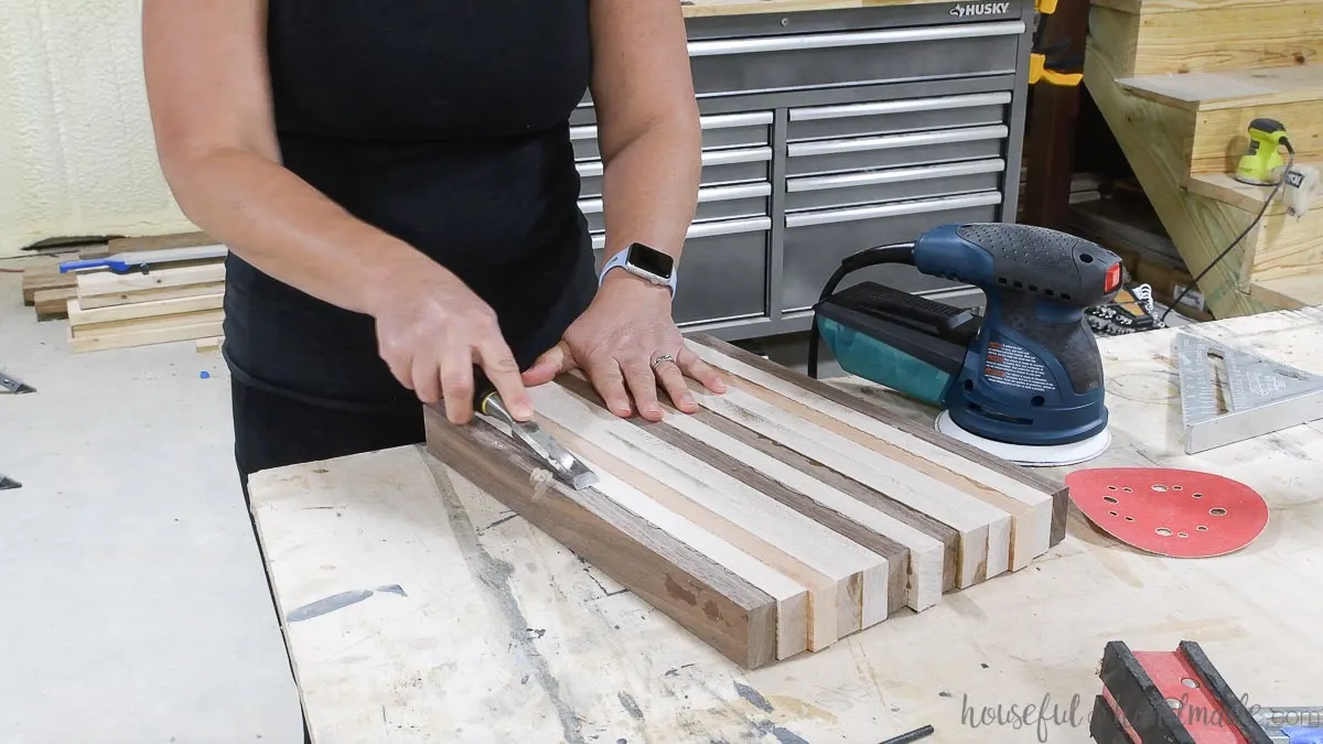 Removing the glue squeeze of the DIY cutting board out with a chisel. 