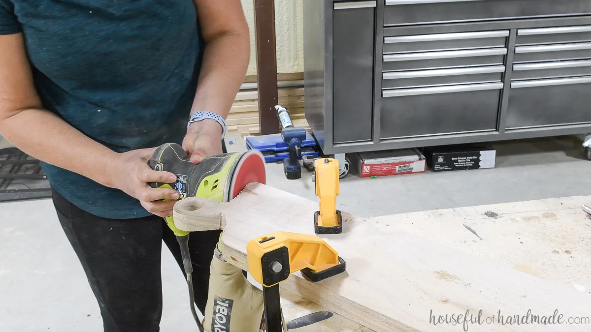 Sanding the edges of the DIY breadboard smooth with an orbital sander. 