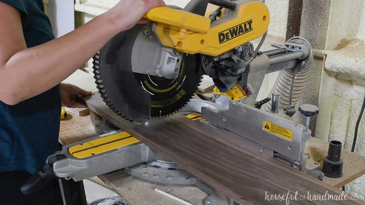 Cutting a walnut board on a miter saw. 