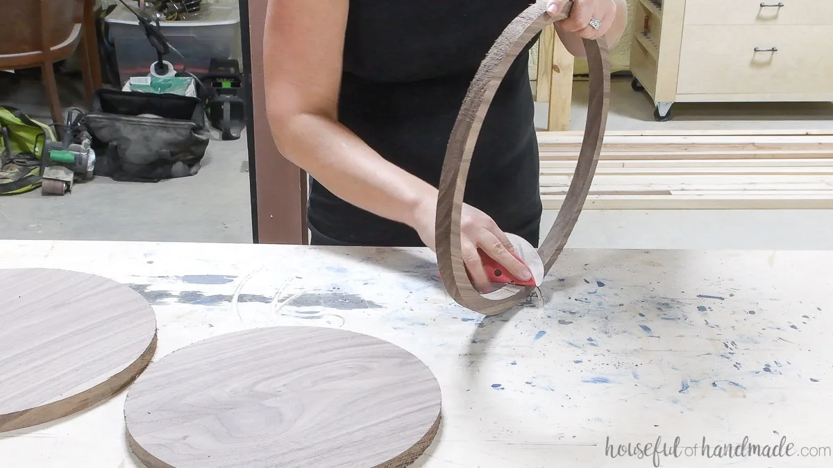 Hand sanding the inside of the thin circle for the DIY round tray. 