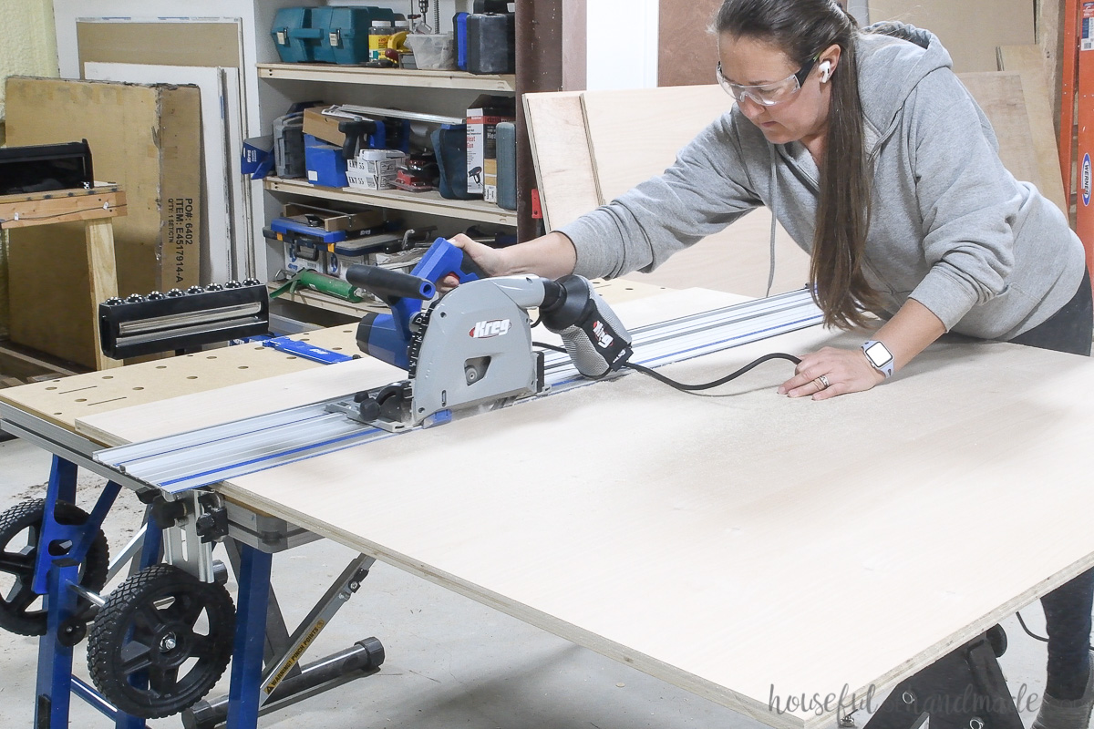 Cutting a piece of plywood for the display cabinet with a track saw. 