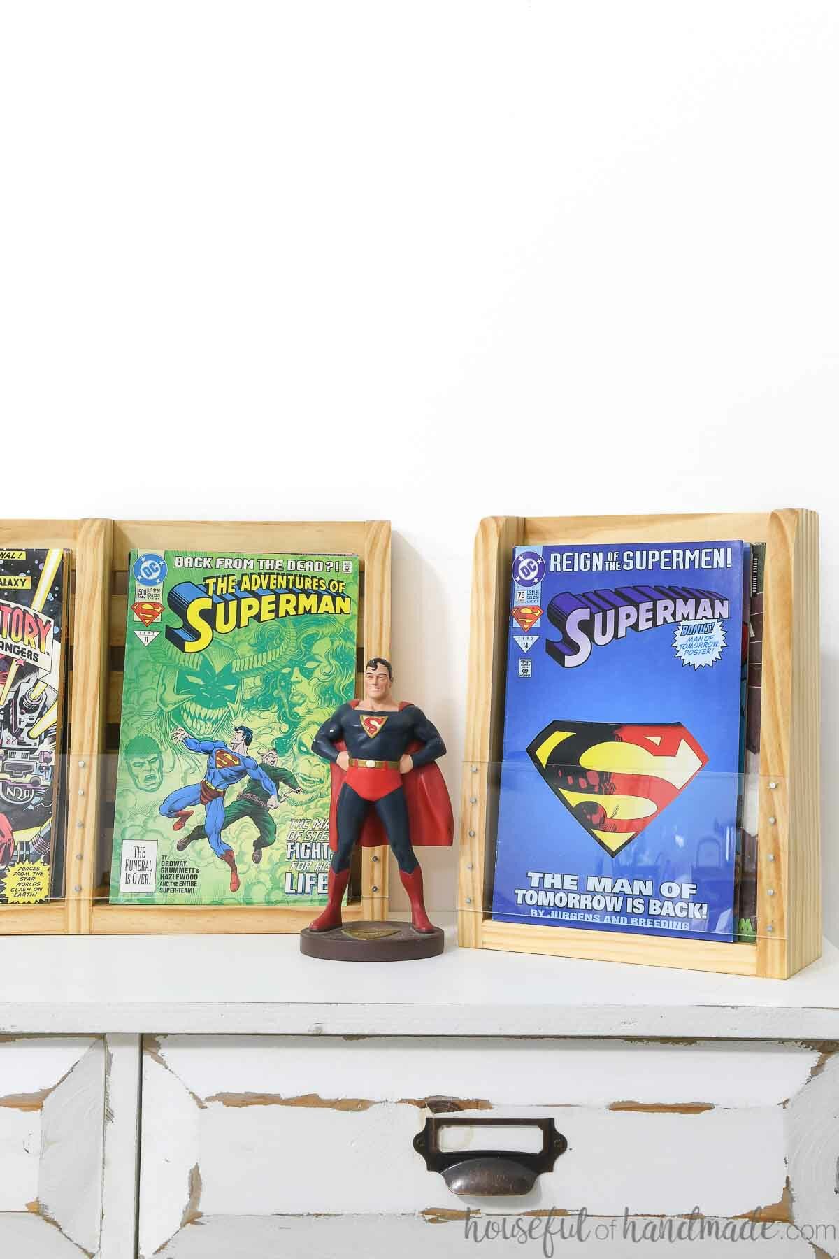 Superman figurine next to the comic book display shelves filled with comic books. 