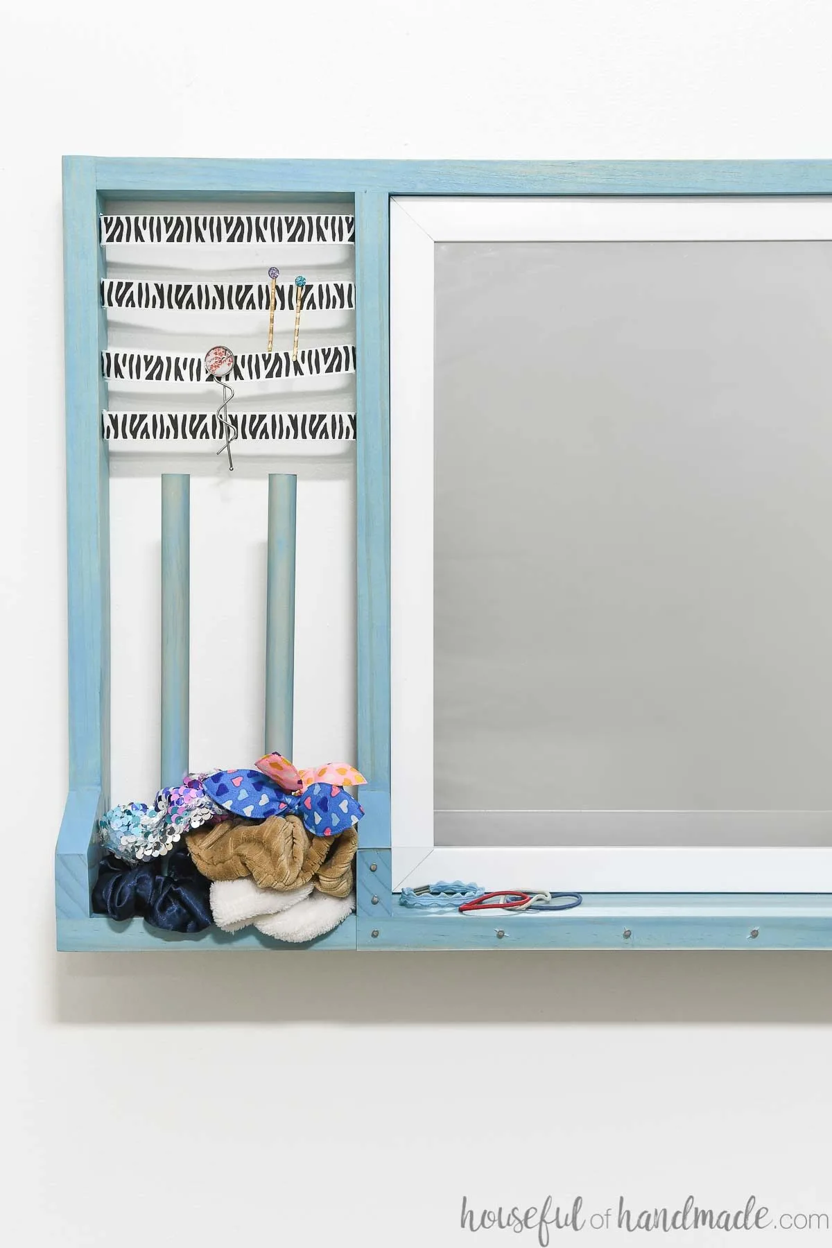Turquoise blue stained hair accessory organizer with a  mirror and dowels for scrunchie storage. 