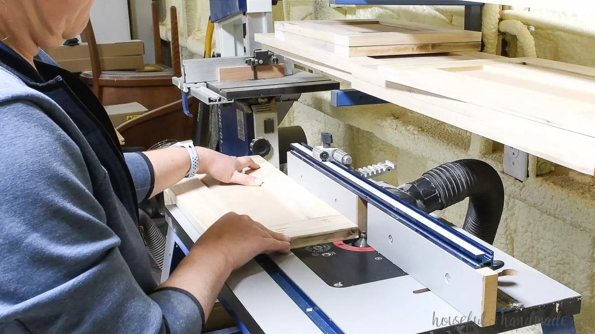 Routing a chamfer on the cabinet doors with a router table. 