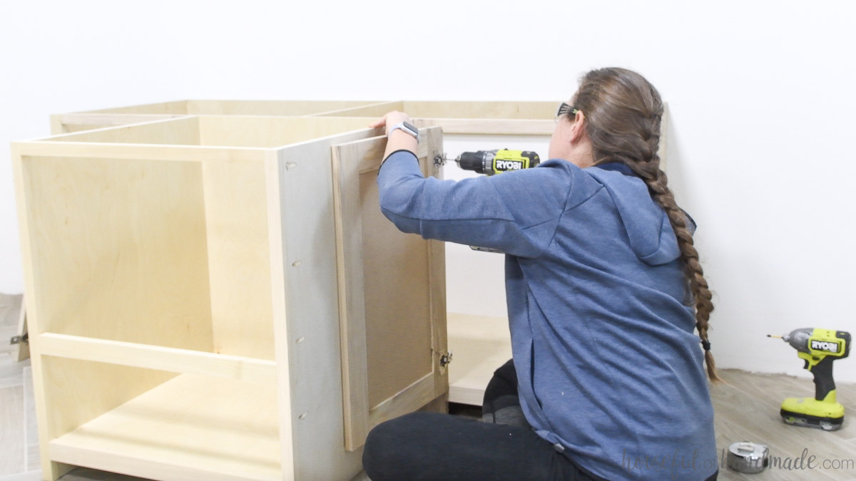 Installing a cabinet door in the DIY built in desk with concealed hinges. 