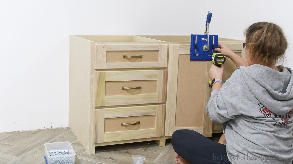 Drilling a hole for the cabinet door knob with a jig. 