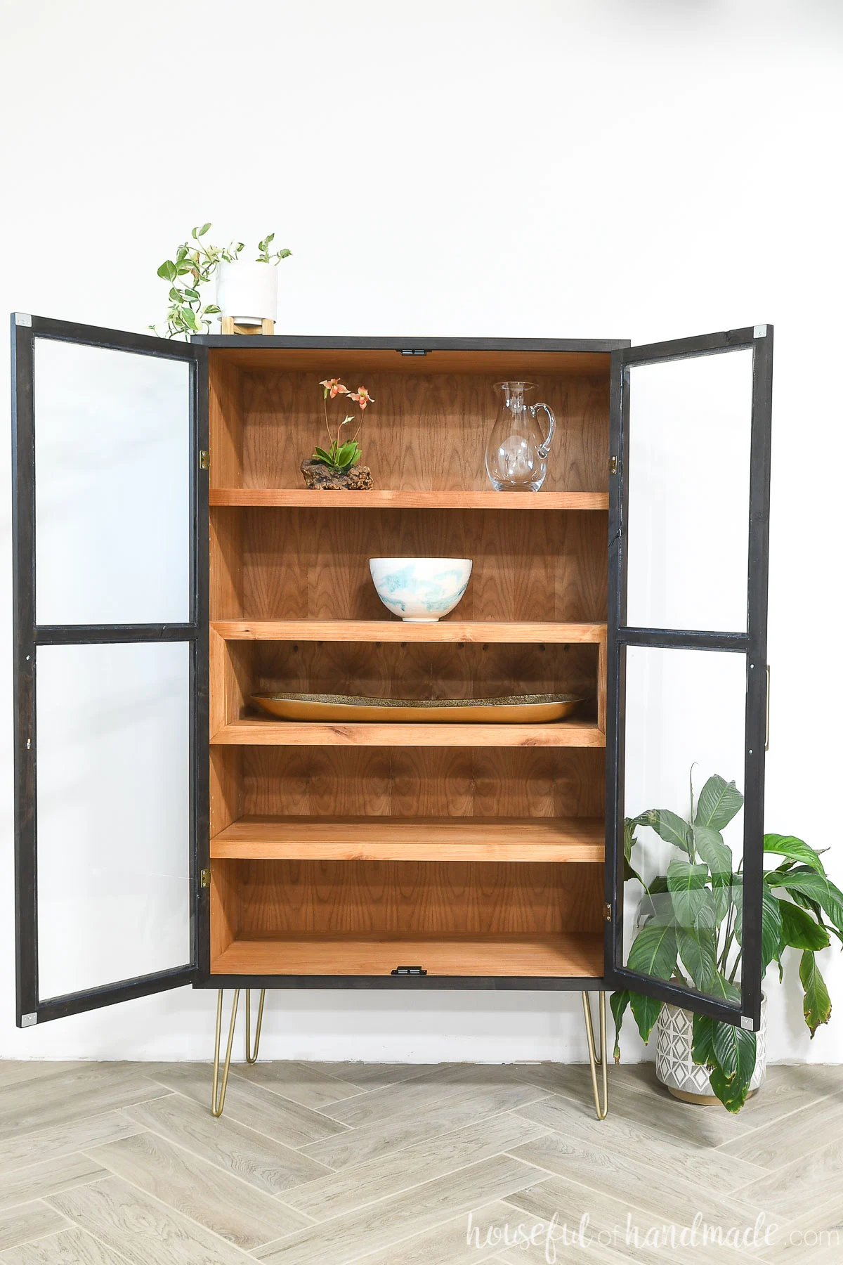 DIY Curio cabinet with two glass front doors shown open and 4 shelves inside.