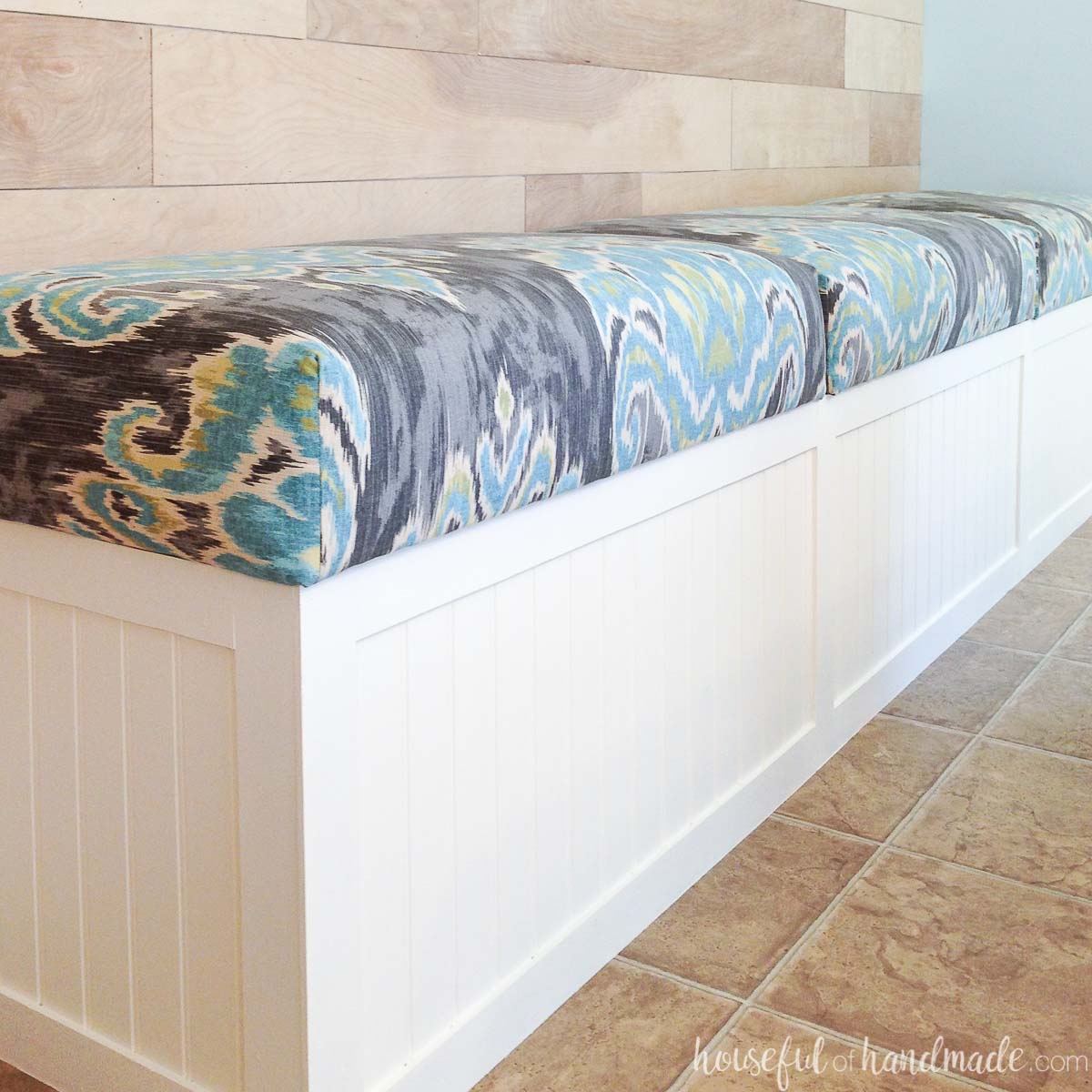 DIY white beadboard paneled built in bench with upholstered top in the dining room.