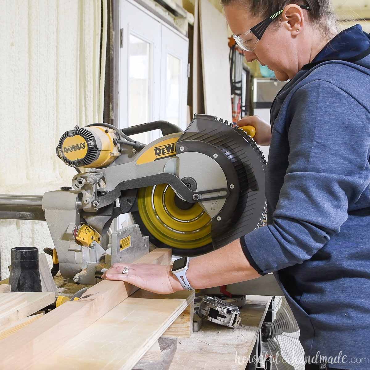 Girl cutting 2x2 boards on a sliding compound miter saw for the blanket ladder build. 