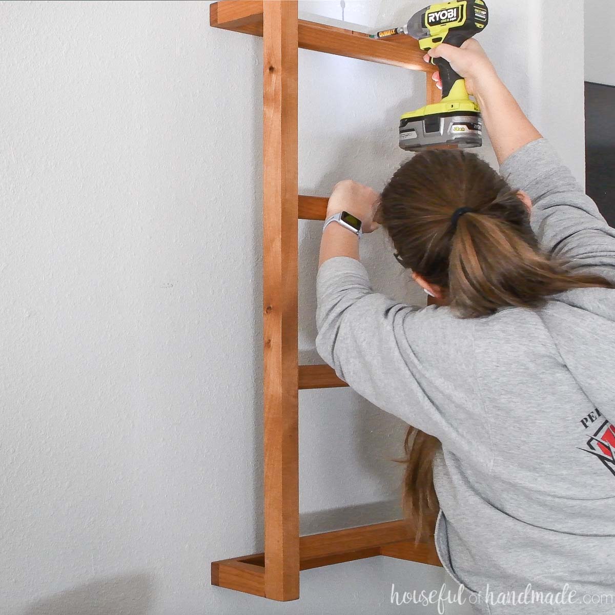 Securing the wooden wall ladder to the wall. 