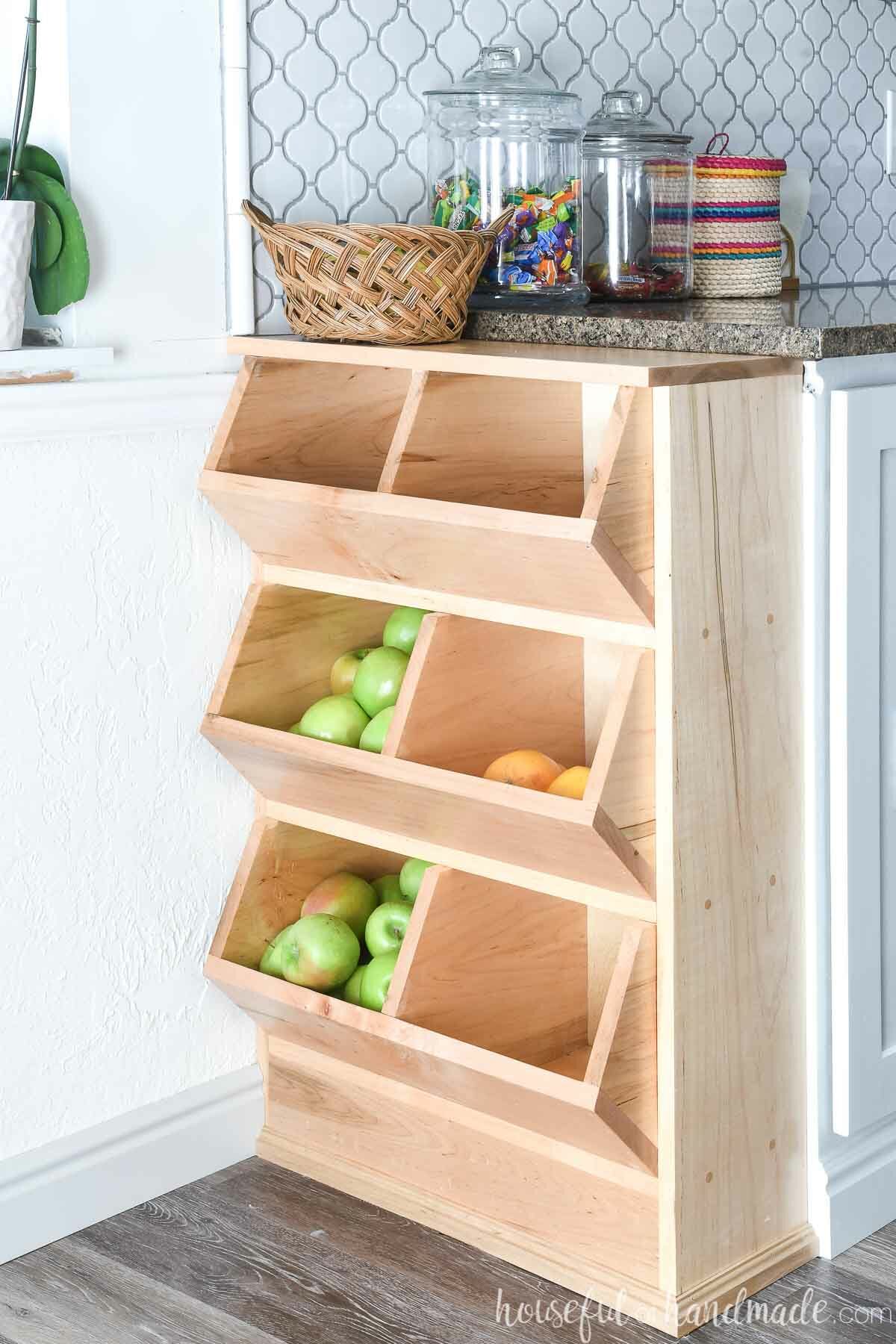 Maple wood open vegetable bin attached to the end of the bank of kitchen cabinets. 