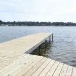 Dock over a lake with replaced deck boards installed.
