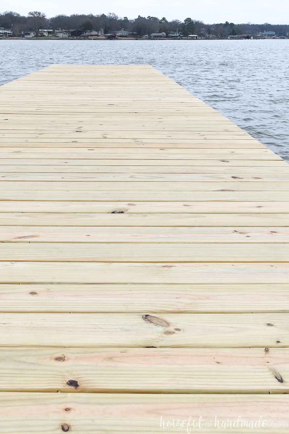 New pressure-treated deck boards on a dock with 1/4" spacing and hidden deck screws. 