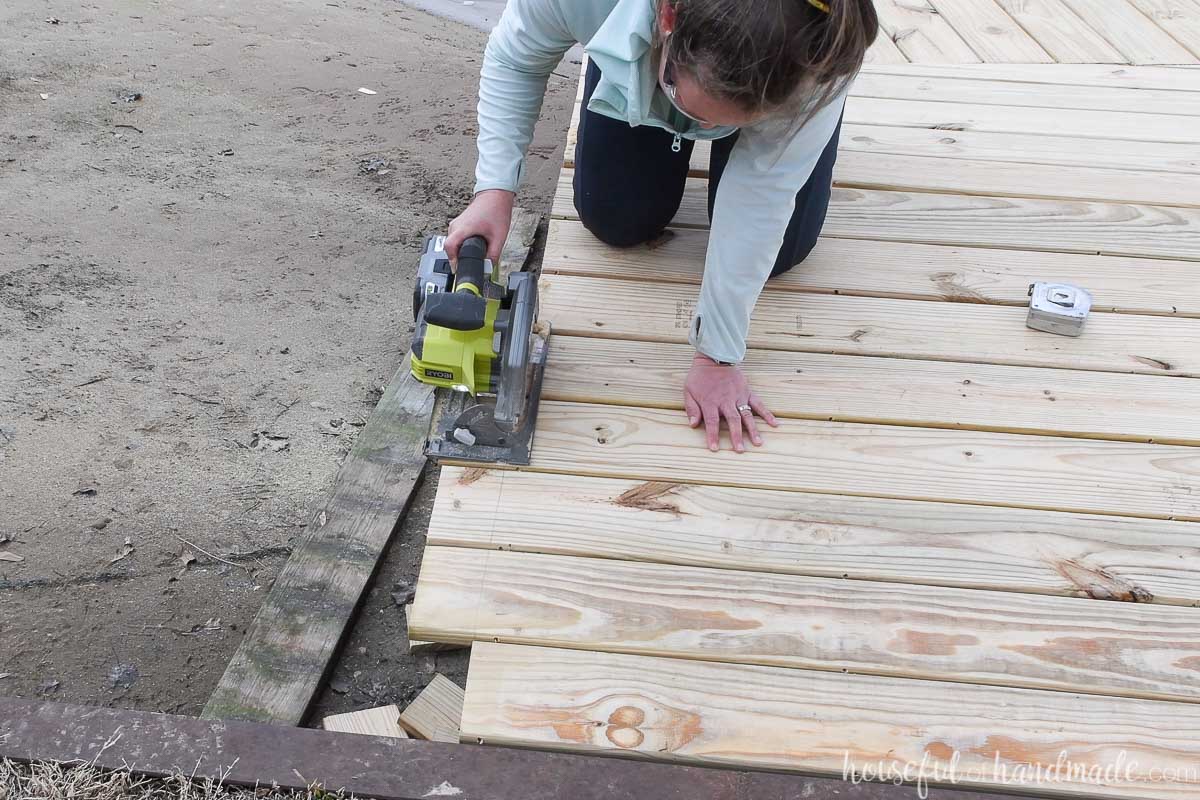 Trimming the edges of the newly installed deck boards with a battery powered circular saw. 