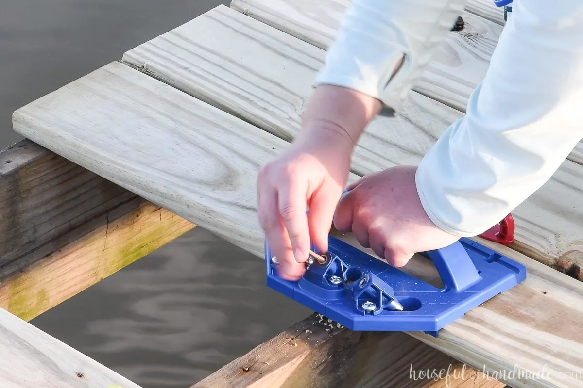 Placing a deck screw in the guide on the Kreg Deck jig. 
