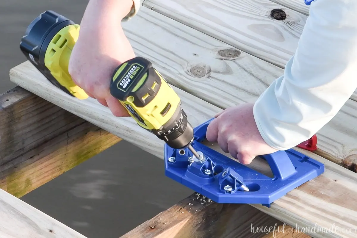 Securing the hidden screw into the side of the deck board with the Kreg deck jig. 