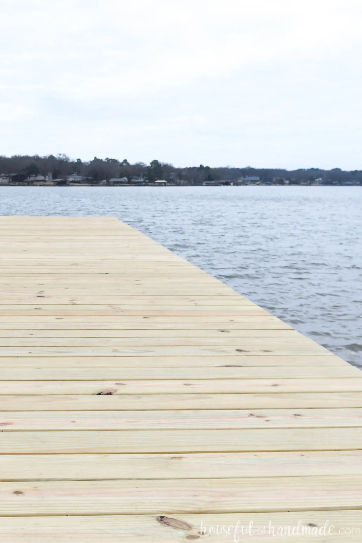 Deck boards with hidden screws on a dock overlooking a lake. 