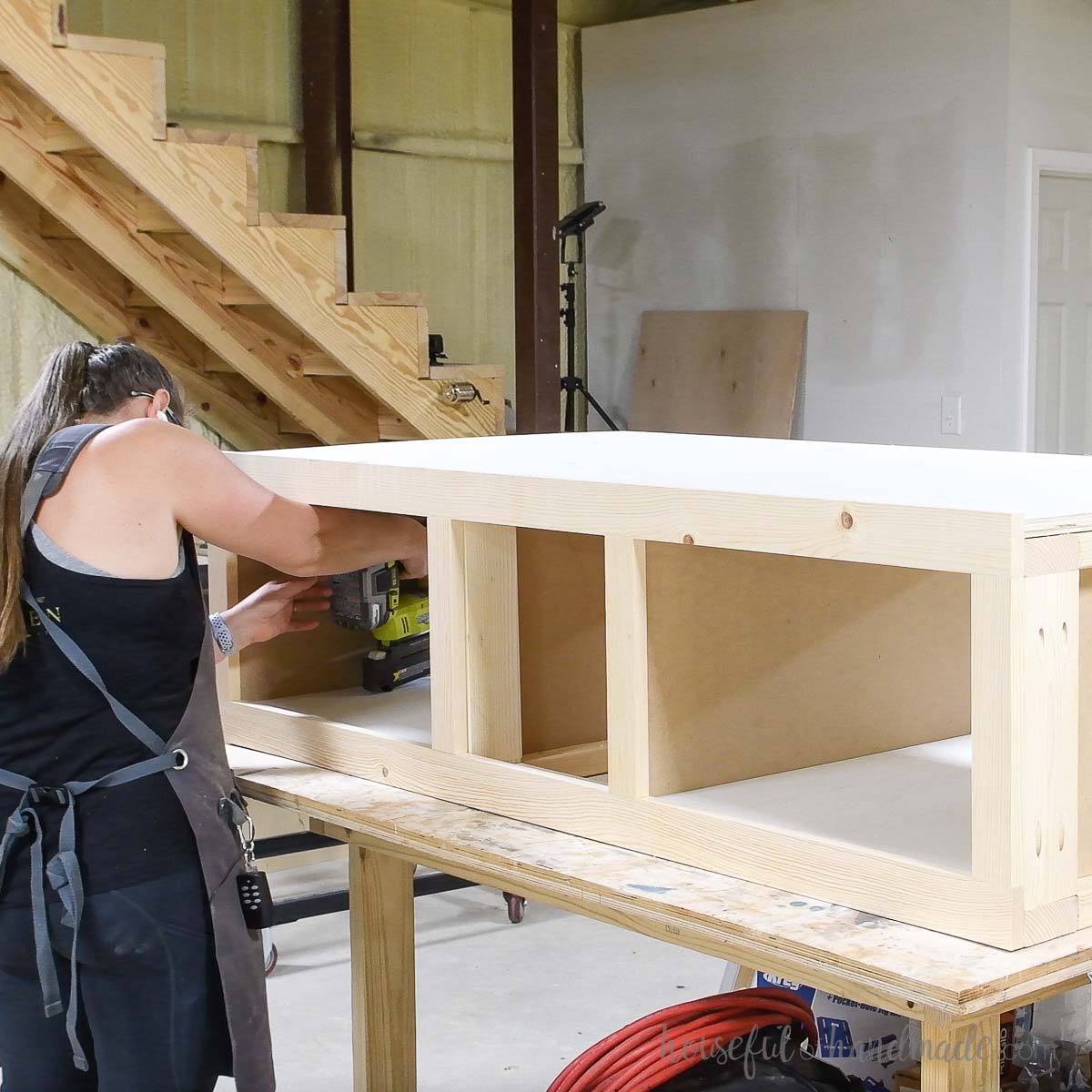 Attaching the plywood to the top of the pedestal and inside the shelves. 