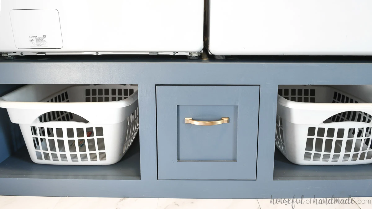 Two laundry baskets and a drawer in the washing machine pedestal. 