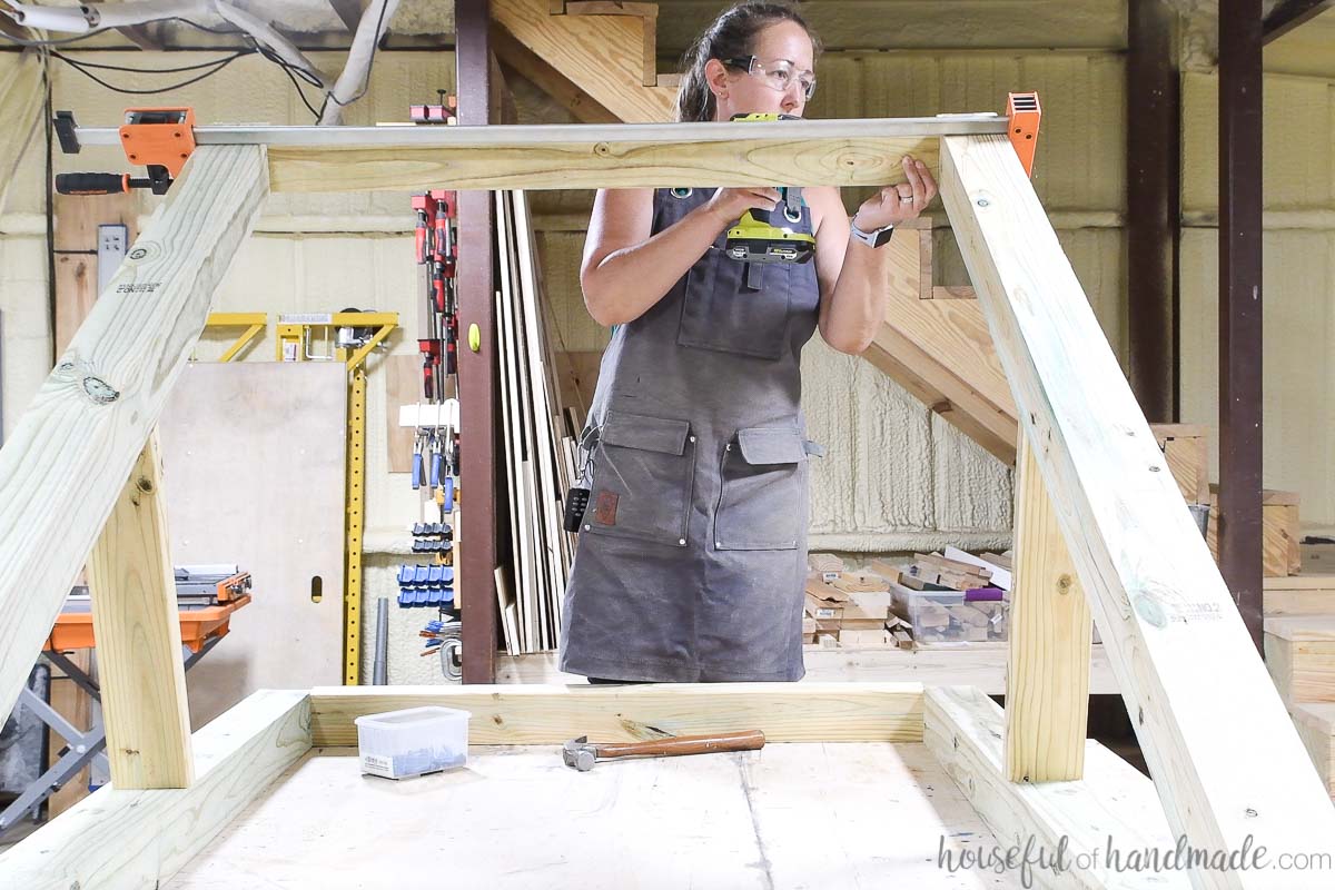 Connecting the legs of the hanging chair stand together at the bottom with 2x4 boards. 