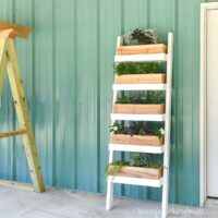 Tiered ladder planter with cedar boxes filled with flowers.