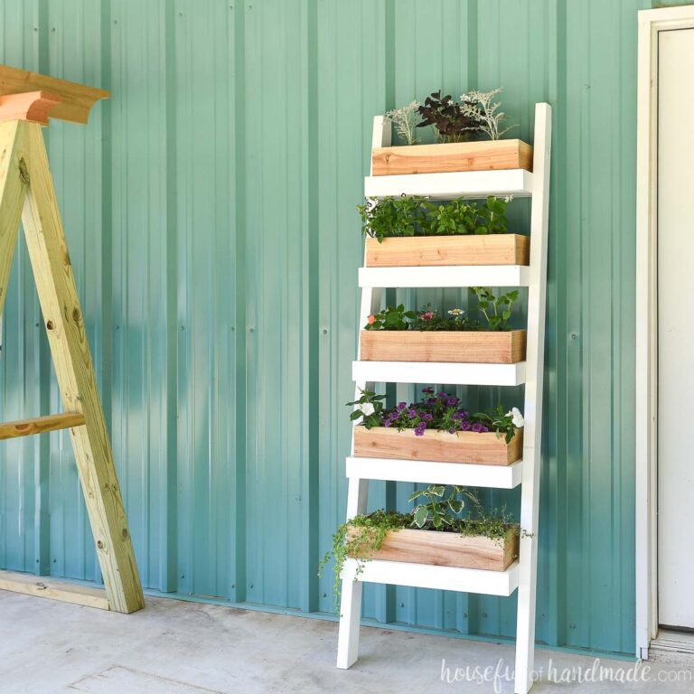 Tiered ladder planter with cedar boxes filled with flowers.