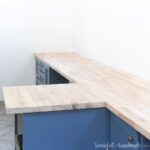 Birch butcher block installed as countertop over blue cabinets.
