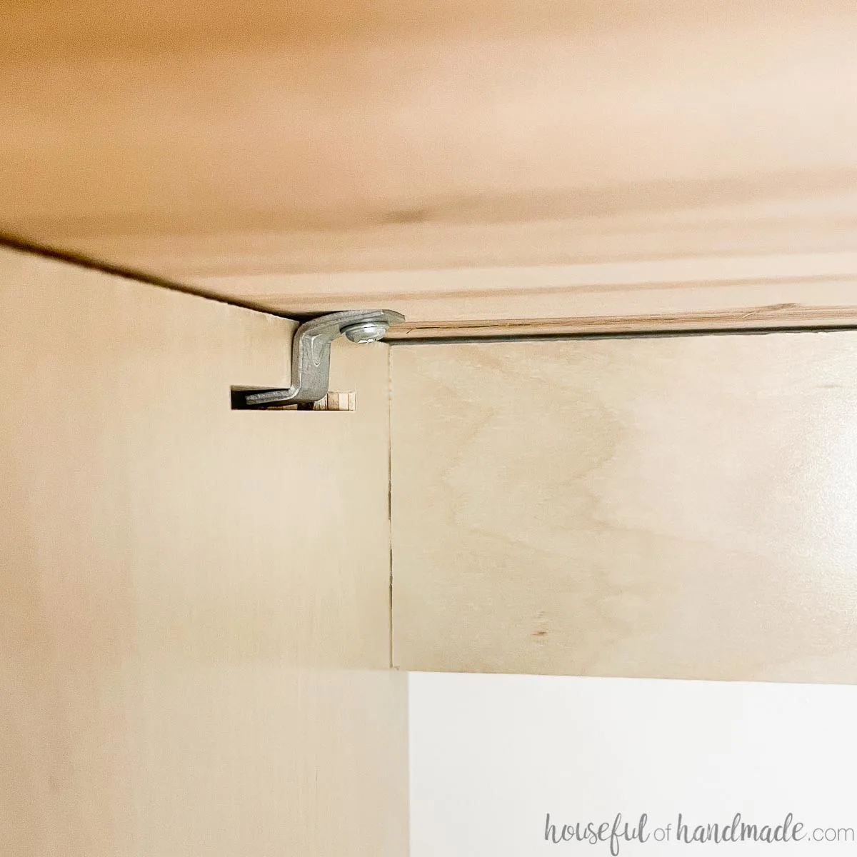 A Z tabletop fastener securing a butcher block countertop to a cabinet. 