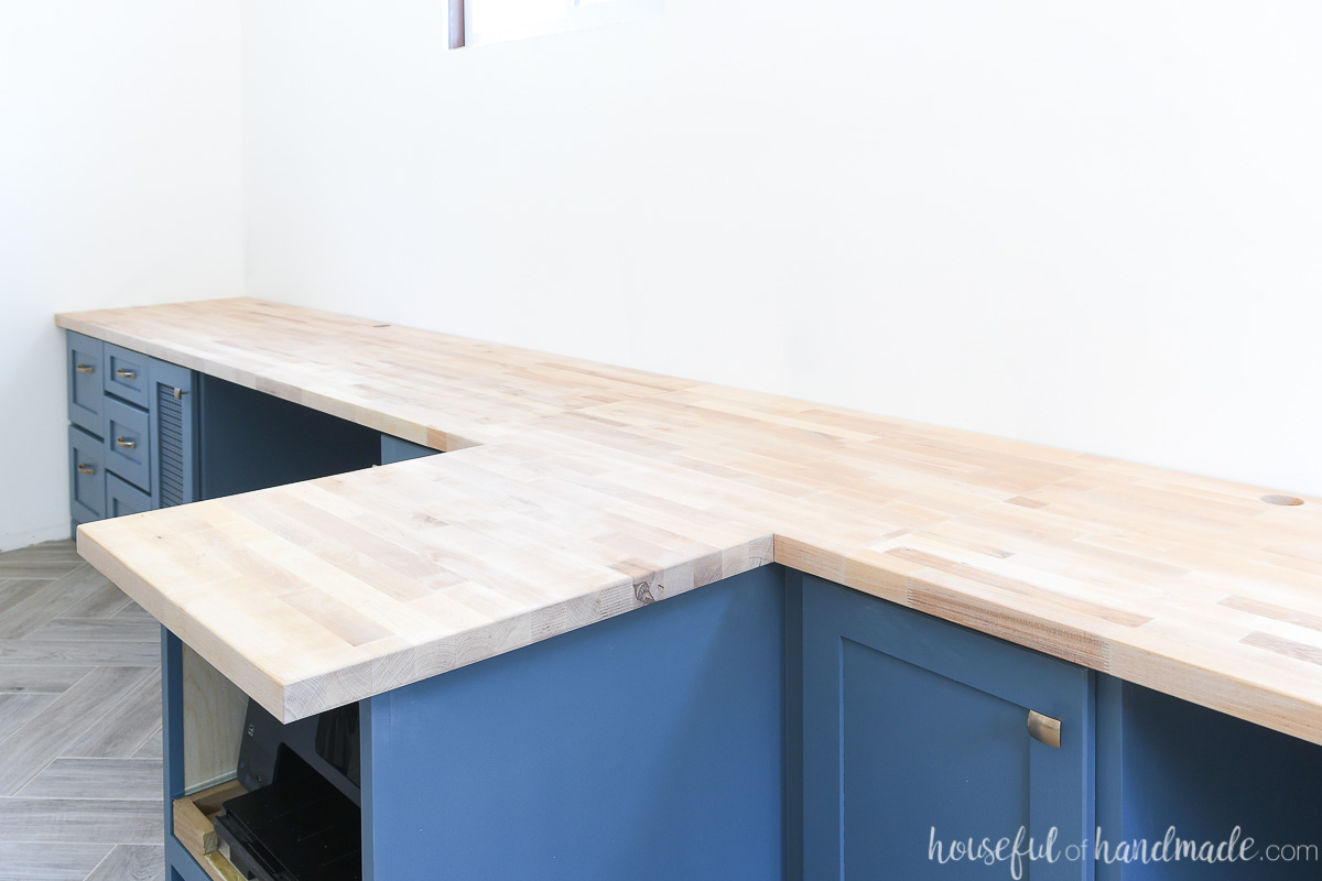 Birch butcher block countertop sealed with matte, unfinished sealer on top of blue cabinets. 
