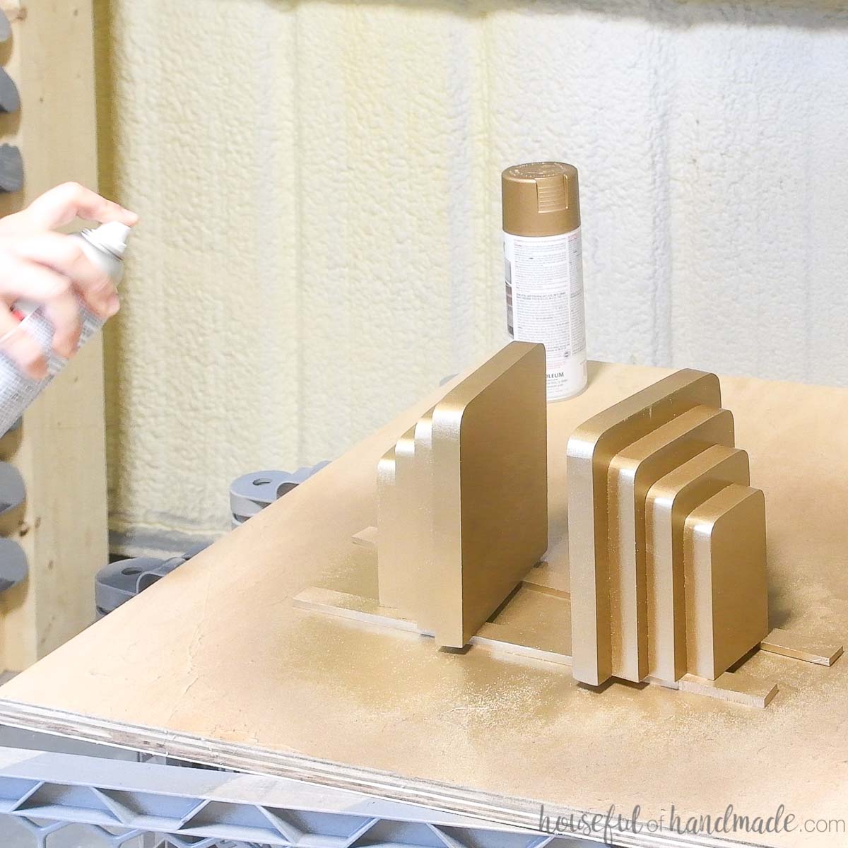 Spray painting the wood bookends to look like brass. 