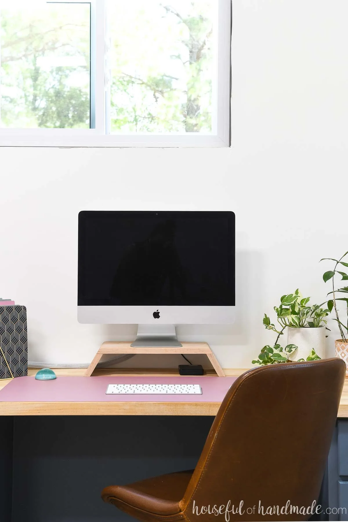 Home office with built in desk using a homemade monitor stand to lift up iMac computer. 