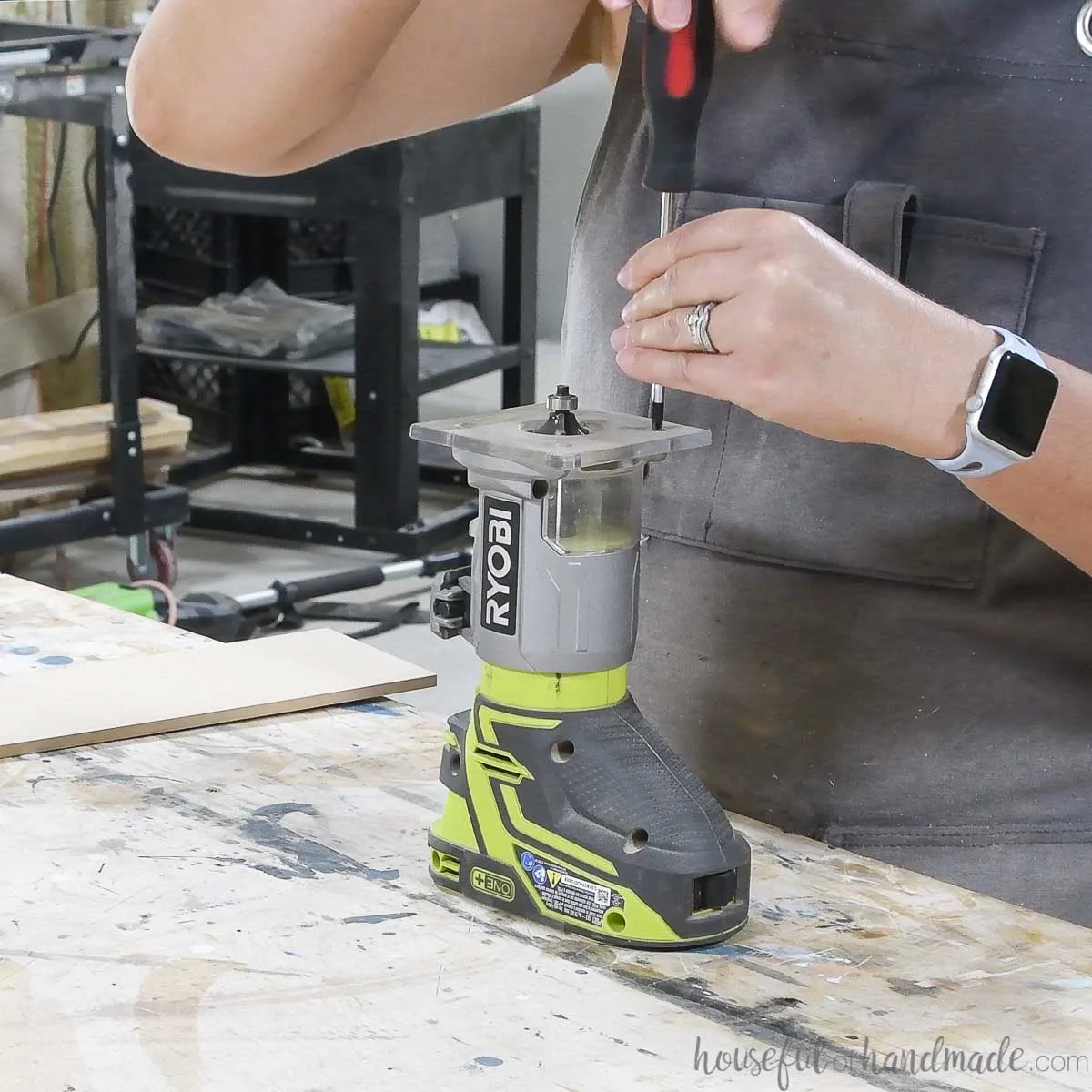 Unscrewing the plate from the top of a Ryobi trim router. 