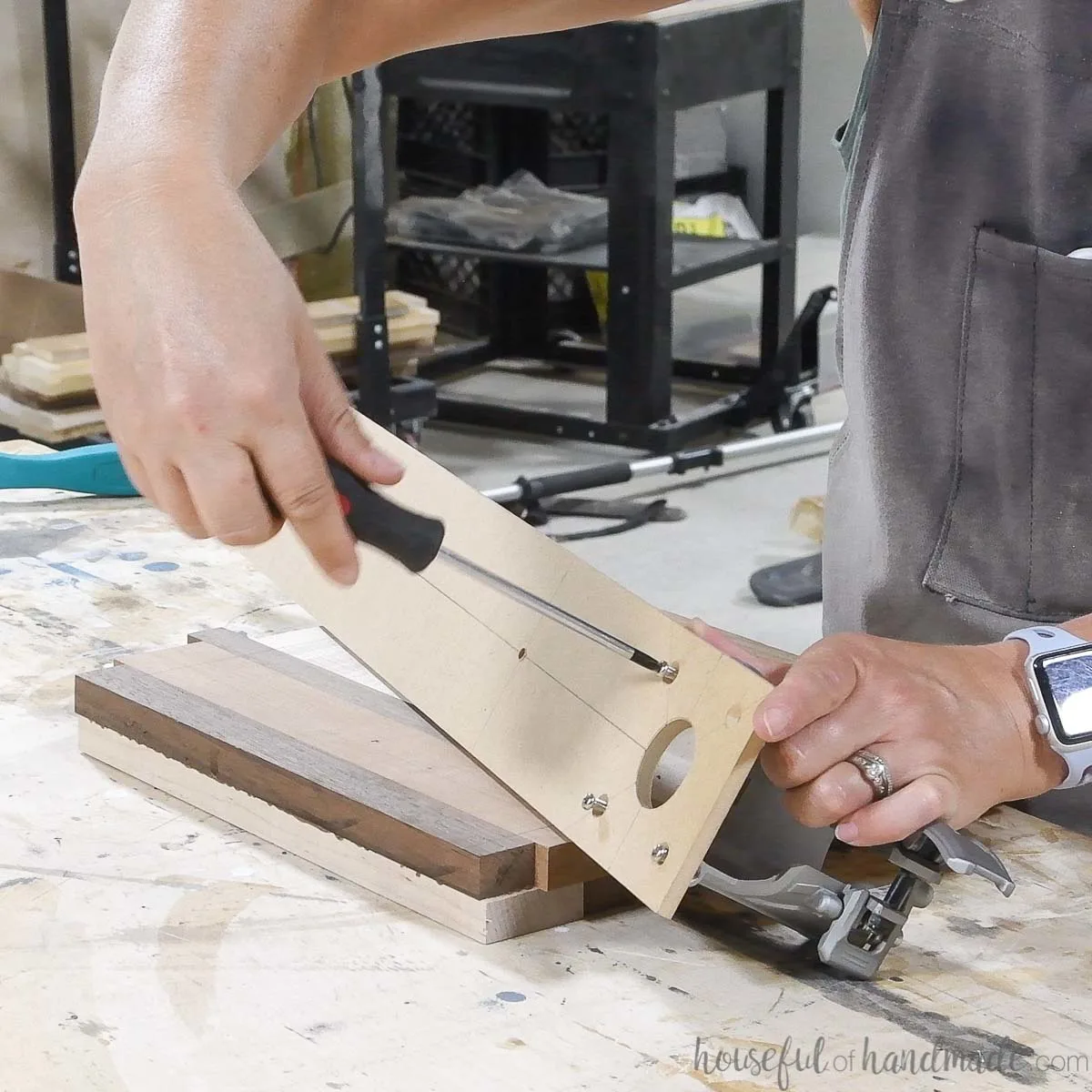 Securing the circle cutting router jig to the router with screws. 