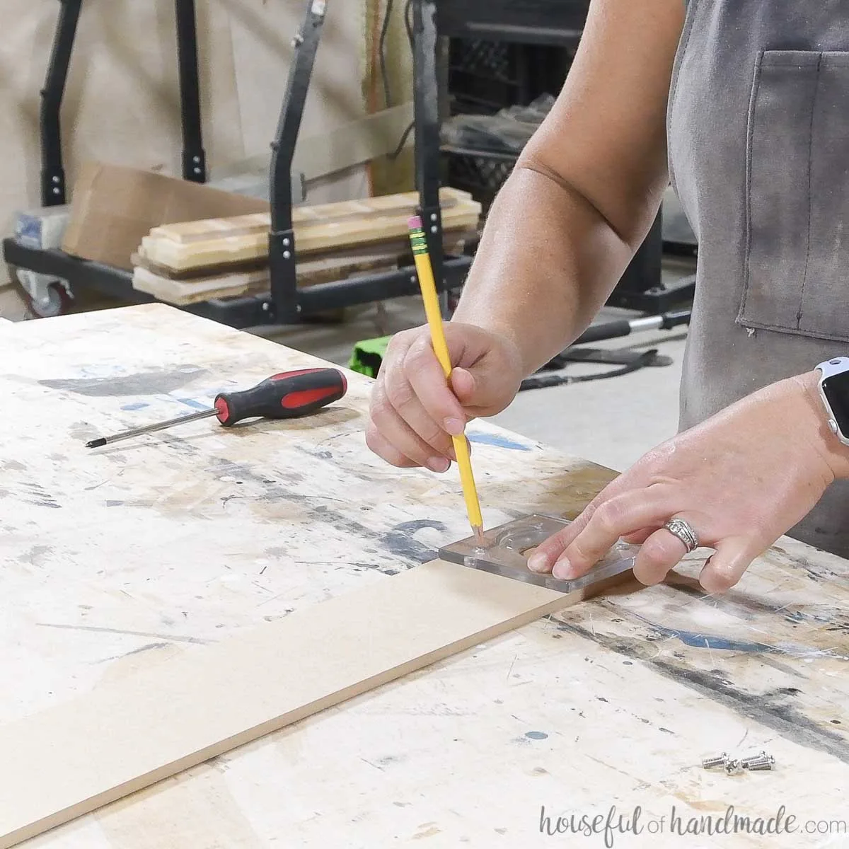 Tracing the holes of the router plate onto the MDF board. 