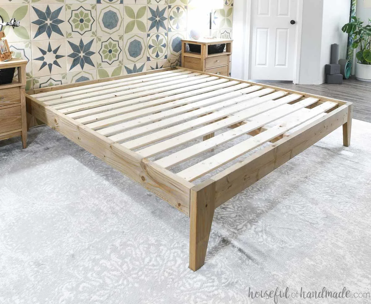 Completed platform bed frame with slats in a room before the mattress is added. 