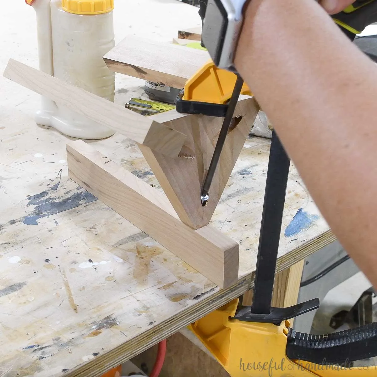 Clamping the shelf to the legs and attaching it with a screw. 