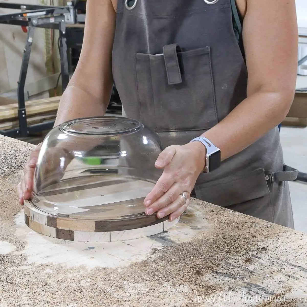 Placing the glass bowl upside down inside the groove on the stand. 