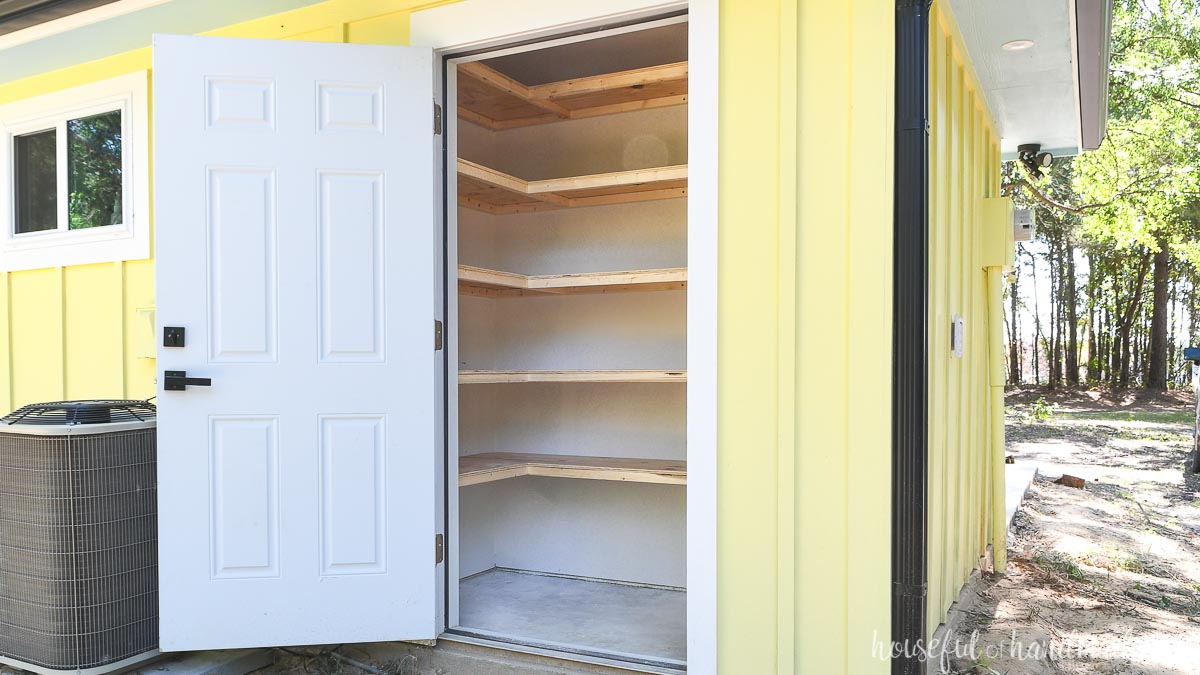 Homemade storage shelves in a closet on the outside of a house. 