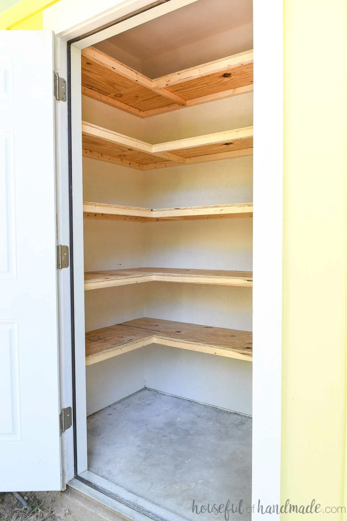 Outdoor storage closet with 5 storage shelves in an L shape. 